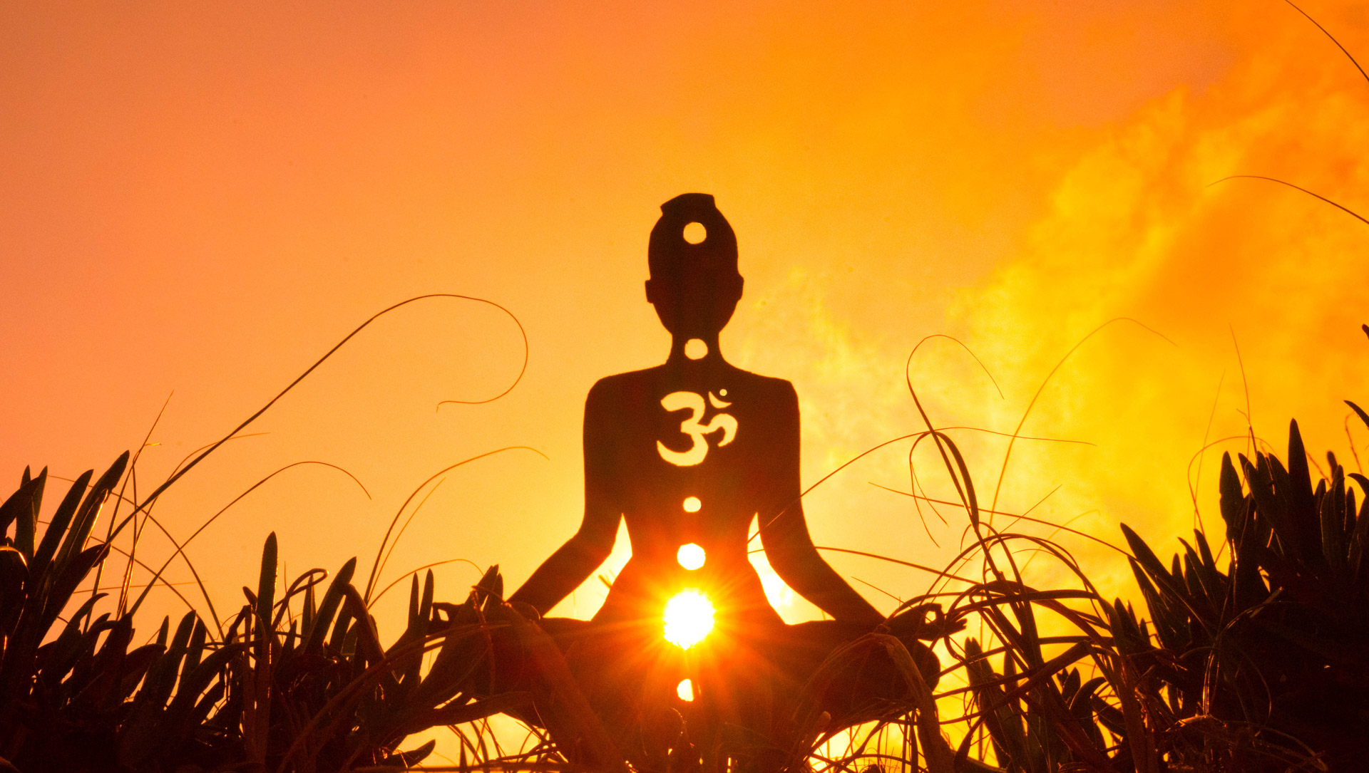 Silhouette of a person doing yoga with the root chakra symbol